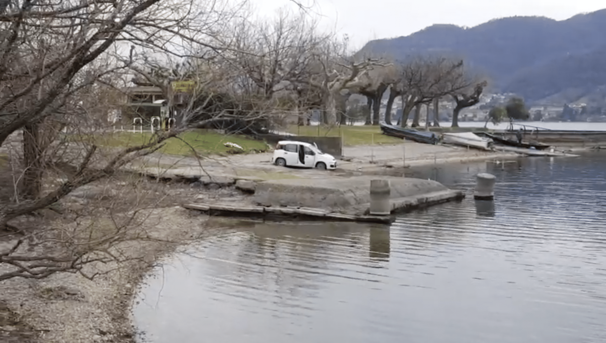 Il cadavere di una donna è stato trovato in un’auto a Lecco in riva a un lago. I sommozzatori stanno cercando altri corpi in acqua,